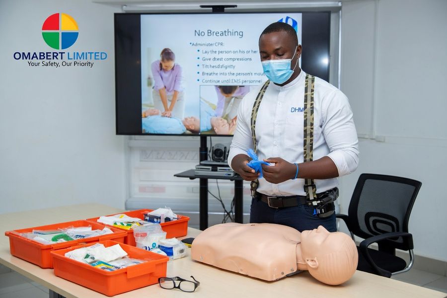 A first aid trainer preparing a CPR demonstration with a manikin and first aid kits
